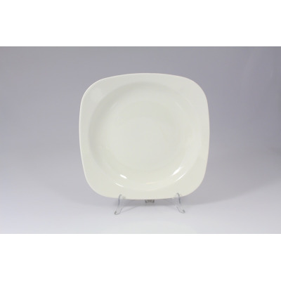 Kwadratowy talerz głęboki RAK Porcelain o średnicy 27 cm z serii SKA. Minimalistyczne naczynie w kolorze złamanej bieli, ustawione na przezroczystym stojaku.