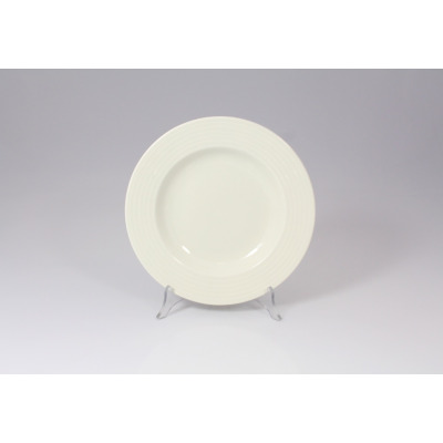 Talerz głęboki RONDO marki RAK Porcelain o średnicy 23 cm. Białe naczynie z subtelnym, żłobionym wzorem na szerokim kołnierzu, wyeksponowane na przezroczystym