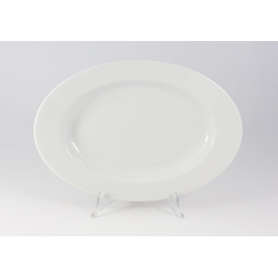 Biały, owalny półmisek Kaszub marki Lubiana o długości 33 cm. Klasyczna, gładka porcelana o minimalistycznym designie, ustawiona na przezroczystym stojaku.