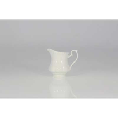 Biały porcelanowy dzbanek do mleczka 0,15 l z serii Iwona marki Chodzież. Klasyczne naczynie o profilowanych ściankach i ozdobnym uchwycie na jasnym tle.