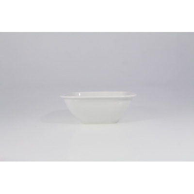 Biała salaterka kwadratowa Lubiana LIKE o wymiarach 18,5 cm. Minimalistyczne naczynie z porcelany o gładkiej powierzchni, ujęte z profilu na jasnym tle.