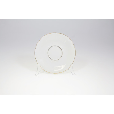 Biały porcelanowy spodek Ćmielów 3604 Feston o średnicy 15,7 cm z delikatnie falowanym brzegiem i subtelną złotą linią na krawędzi oraz okręgu podstawy.
