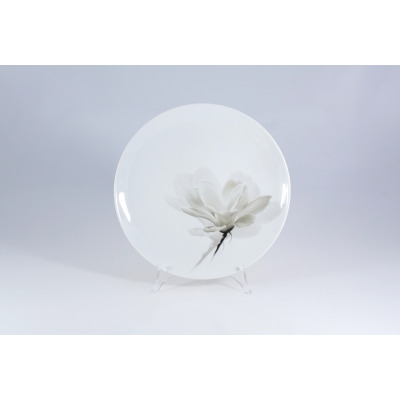 Biały talerz płytki 27 cm Lubiana z serii 6474 Magnolia. Porcelanowe naczynie o gładkiej powierzchni ozdobione subtelnym, szarym motywem kwiatu magnolii.