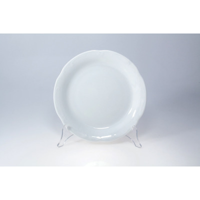 Biały talerz płytki 24 cm z kolekcji Kamelia marki Chodzież. Klasyczna porcelana o gładkiej powierzchni z subtelnym, falistym zdobieniem na obrzeżach, na