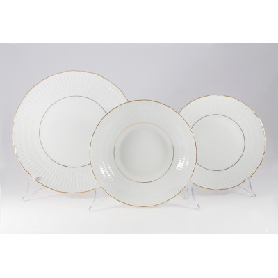 Trzy białe talerze z zestawu obiadowego Ćmielów 3604 Sofia. Naczynia z porcelany zdobione delikatną fakturą i eleganckim złotym obrzeżem, ustawione na