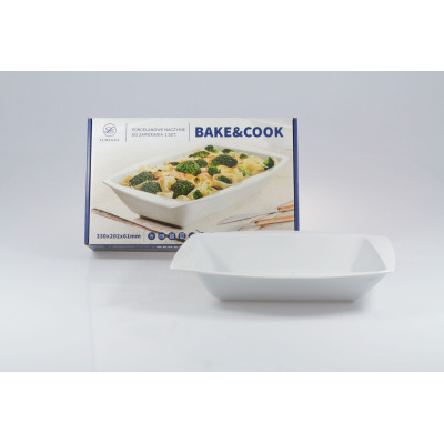 Białe porcelanowe naczynie do zapiekania Lubiana Rumba 330x202x61mm na tle opakowania z napisem BAKE&COOK. Produkt o prostokątnym kształcie i nowoczesnym