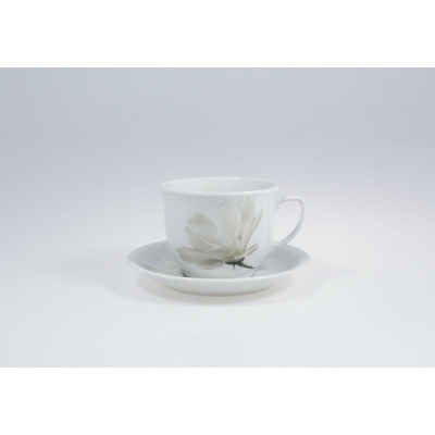 Biały porcelanowy kubek 300 ml ze spodkiem Lubiana z serii Magnolia (Wiedeń). Naczynie ozdobione subtelnym motywem kwiatowym, widoczne z profilu na jasnym tle.