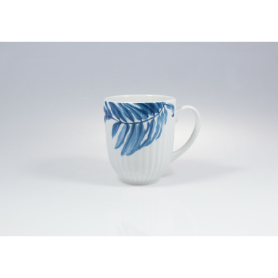 Biały porcelanowy kubek 350 ml 7260 Daisy marki Lubiana z pionowym żłobkowaniem. Naczynie zdobi elegancki, niebieski motyw roślinny w formie liścia paproci.