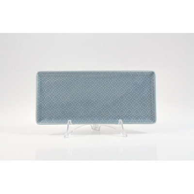 Niebieski półmisek prostokątny 29x13 cm z serii Marrakesz marki Lubiana. Ceramiczne naczynie ozdobione jest geometrycznym wzorem, ustawione na przezroczystym