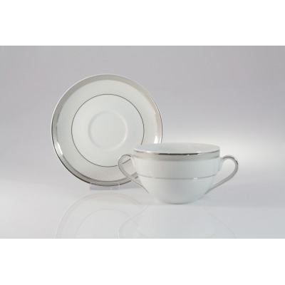 Biała bulionówka 0,35 l ze spodkiem Ćmielów E685 Yvonne. Porcelanowe naczynie z dwoma uszkami i delikatnym srebrnym zdobieniem w stylu klasycznym na jasnym tle.