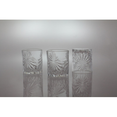 Trzy szklanki kryształowe Bohemia Prestige Fiore 320 ml z ozdobnym szlifem w kształcie gwiazd. Dwie stoją pionowo, jedna odwrócona dnem do góry na jasnym tle.
