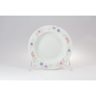 Talerz głęboki 23 cm G679 YVETTE marki Chodzież z porcelany o białym odcieniu, ozdobiony delikatnym motywem kwiatowym w odcieniach różu i błękitu na rancie.