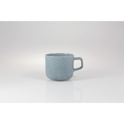 Filiżanka 250 ml K90E Marrakesz marki Lubiana w kolorze niebieskim. Ceramiczne naczynie z geometrycznym, wypukłym wzorem, ujęte z profilu na białym tle.