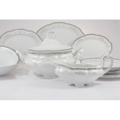 Zestaw obiadowy Ćmielów E361 Bolero Vera dla 6 osób. Biała porcelana z delikatnym srebrnym zdobieniem, waza z pokrywką i sosjerka na pierwszym planie, w tle