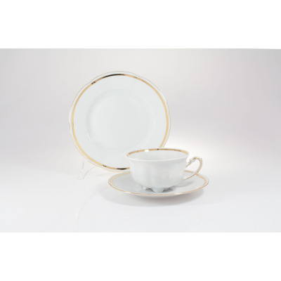 Zestaw do herbaty Ćmielów E337 Bolero: biała porcelanowa filiżanka ze spodkiem i talerzykiem deserowym, zdobione elegancką złotą linią na krawędziach.