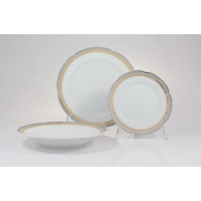 Zestaw obiadowy Ćmielów E551 Bolero Princess dla 6 osób. Trzy białe porcelanowe talerze z eleganckim złotym i srebrnym zdobieniem na falistych brzegach.