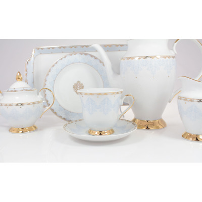 Elegancki zestaw kawowy Ćmielów ASTRA Królewski Błękit dla 6 osób. Biała porcelana z subtelnym błękitnym wzorem i złotymi zdobieniami, obejmująca dzbanek