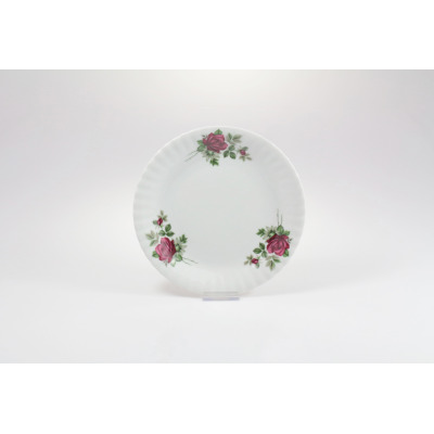 Talerz deserowy Chodzież Iwona o średnicy 19 cm z białej porcelany. Dekorację stanowi motyw bordowej róży z zielonymi liśćmi, umieszczony na karbowanym brzegu