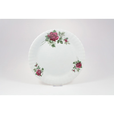 Talerz płytki 24 cm Chodzież B826 Iwona z motywem bordowej róży. Biała porcelana o falistym brzegu z delikatnym kwiatowym zdobieniem, widok z przodu na stojaku.