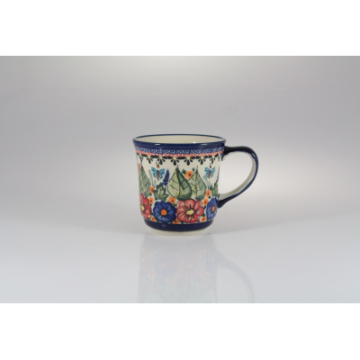 Ceramiczny kubek Bolesławiec 380 ml model GU-1194 z ręcznie malowanym wzorem kwiatów, liści i motyli w odcieniach niebieskiego, czerwonego i zieleni na białym