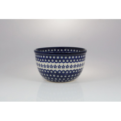 Ceramiczna misa Bolesławiec 166A o średnicy 20,5 cm. Naczynie zdobi tradycyjny granatowy wzór w kropki i kwiaty na białym tle, widoczne z profilu na jasnym tle.