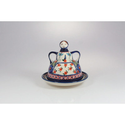 Ceramiczna baba do sera Bolesławiec 149AR o wysokości 12 cm. Naczynie z pokrywką w kształcie figurki kobiety, zdobione kwiatowym wzorem GU-1124 na jasnym tle.