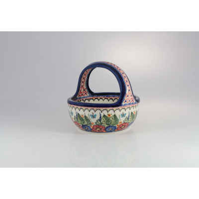 Ceramiczny koszyk Bolesławiec 149AR o średnicy 17,5 cm. Naczynie zdobione ręcznie malowanym motywem kwiatów, liści i motyli w stylu ludowym na jasnym tle.