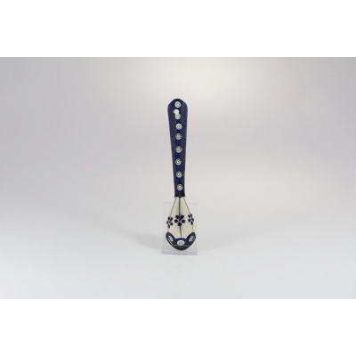 Ceramiczna łyżka Bolesławiec 18 cm GU-1760A z charakterystycznym wzorem pawich oczek i kwiatów. Naczynie na przezroczystej podstawce, widok z przodu na jasnym