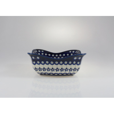 Ceramiczna salaterka Bolesławiec 166A o wymiarach 19,2 x 19,2 cm. Naczynie o falistym brzegu zdobi charakterystyczny wzór w niebieskie kółka i drobne kwiaty.