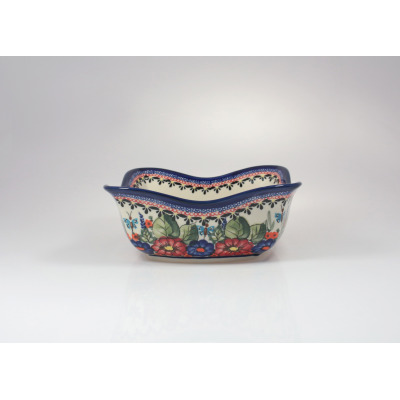 Ceramiczna salaterka Bolesławiec 149AR o wymiarach 19,2x19,2 cm. Naczynie o falistym rancie, zdobione tradycyjnym motywem kwiatów i motyli na jasnym tle.