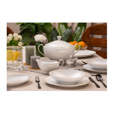 Elegancka waza 2,5 l z kolekcji Dalia Złota linia marki Chodzież na nakrytym stole. Biała porcelana z subtelnym żłobkowaniem i złotym wykończeniem w otoczeniu