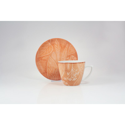 Filiżanka 350 ml ze spodkiem 9075C marki Lubiana w kolorze pomarańczowym. Ceramiczny zestaw zdobiony delikatnym, białym wzorem roślinnym, ustawiony na białym