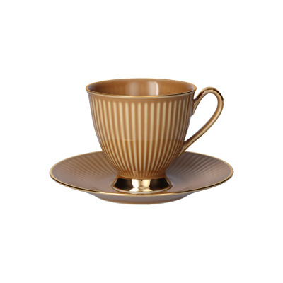 Filiżanka ze spodkiem Dalia Cappuccino marki Chodzież w kolorze kawy z mlekiem. Eleganckie naczynie z pionowymi żłobieniami i złotym wykończeniem podstawy oraz