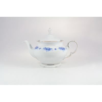 Porcelanowy czajnik Ćmielów G540 Alaska o pojemności 1,15 l. Białe naczynie z delikatnym niebieskim wzorem kwiatowym, złotym wykończeniem krawędzi i pokrywką.