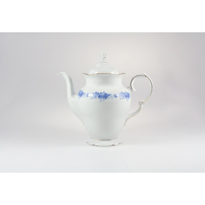 Biały porcelanowy imbryk Ćmielów G540 Alaska o pojemności 1,20 l z delikatnym niebieskim kwiatowym wzorem na brzuścu, złotymi akcentami i profilowaną pokrywką.