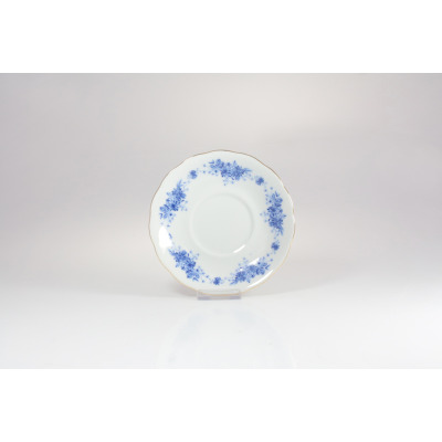 Biały porcelanowy spodek Ćmielów G540 Alaska o średnicy 14 cm z delikatnym niebieskim kwiatowym wzorem na obrzeżach i subtelnym złotym wykończeniem krawędzi.