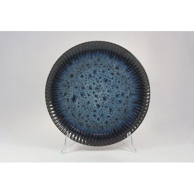 Talerz płytki 31 cm STONEWARE S006T COSMOS marki Lubiana o okrągłym kształcie z karbowanym brzegiem. Granatowa ceramika z nakrapianym wzorem i ciemniejszym