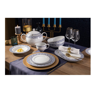 Zestaw obiadowy dla 12 osób Classic Kobalt WA-160 marki Waza na drewnianym stole. Elegancka porcelana z niebieskim wzorem, złote podtalerze, sztućce i