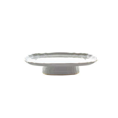 Elegancka patera na nodze Bernadotte Ivory Gold marki Thun o średnicy 40 cm. Wykonana z porcelany w kolorze kości słoniowej, zdobiona reliefami i złotym rantem.